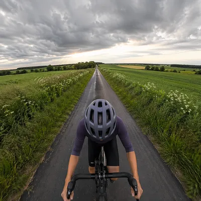 Cyclist on Stormy Countryside Road