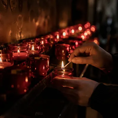 Hands Lighting Red Votive Candle in Church