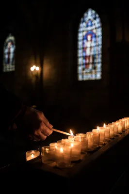 Lighting Votive Candle in Dark Church