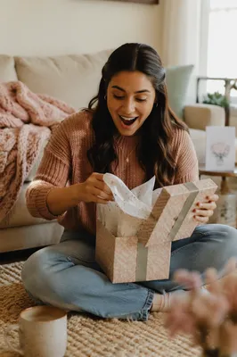 Young Woman Opening Gift Box Indoors