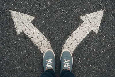 Person Facing Crossroads Decision on Pavement