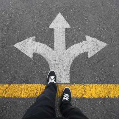 Crossroads Decision With Sneakers on Asphalt
