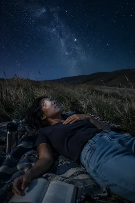 Woman Stargazing on Blanket in Meadow