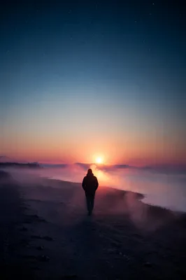 Silhouette Walking Through Coastal Fog Toward Light