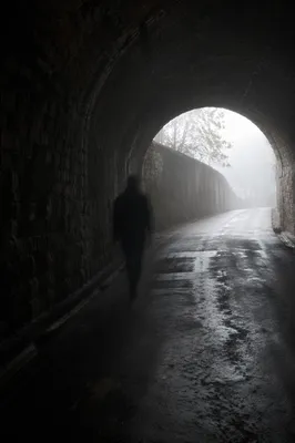 Solitary Figure Walking Through Fog Toward Light