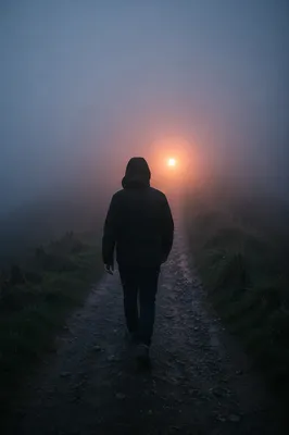 Lone Walker Toward Light in Fog