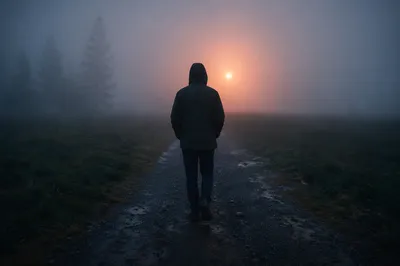 Person Walking Through Fog Toward Light