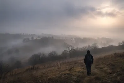 Person Walking Through Fog Toward Light