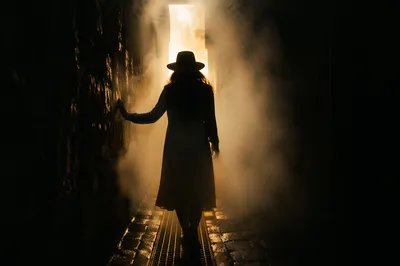 Silhouette Walking Through Fog Toward Light