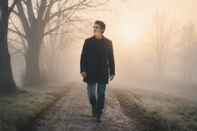 Man Walking Through Foggy Dawn Path