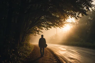 Person Walking Through Fog Toward Light
