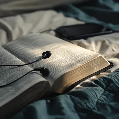 Bible with Earbuds on Morning Bedding