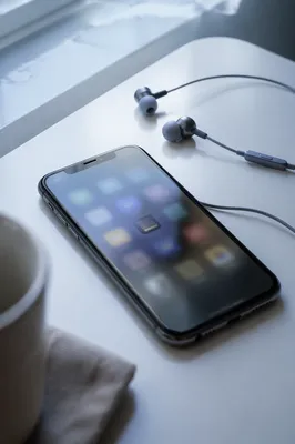 Smartphone and Earbuds on White Desk