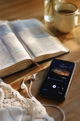 Open Bible with Phone and Earbuds