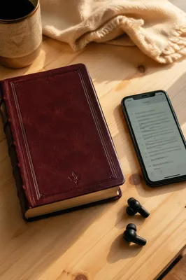 Smartphone Earbuds and Book on Wooden Table