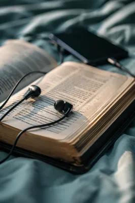 Bible, Earbuds, and Phone on Bedding