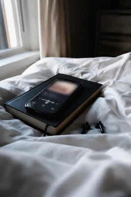Smartphone and Earbuds on Black Bible