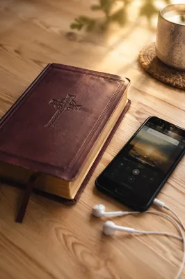Bible, Smartphone and Earbuds on Table