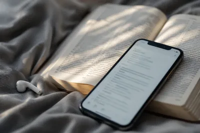 Smartphone on Open Bible in Bed