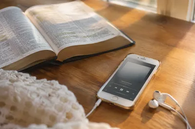 Open Bible and Earbuds on Table
