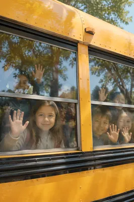 Children Waving from School Bus Window