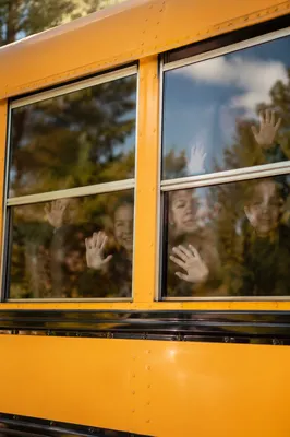 Children Waving From School Bus Windows