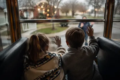 Children Waving Goodbye on Rainy School Bus