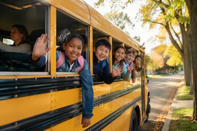 Children Waving from Yellow School Bus