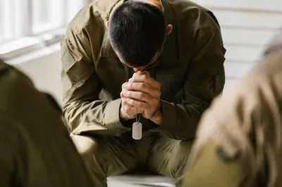 Kneeling Service Member Praying With Dog Tags