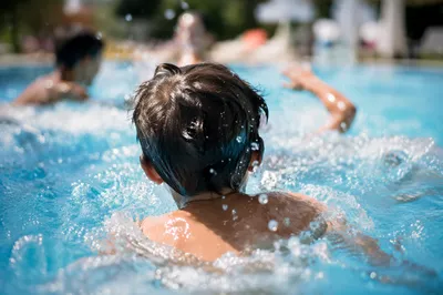 Kids Splashing in Sunny Backyard Pool