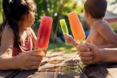 Kids Enjoying Melting Popsicles in Summer