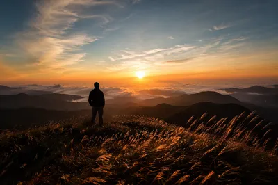 Silhouetted Hiker Watching Golden Mountain Sunset