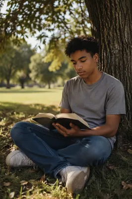 Teenage Boy Reading Under Oak Tree
