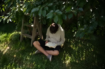 Teenager Reading Bible in Garden Shade