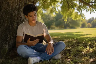 Teen Boy Reading Bible Under Oak Tree