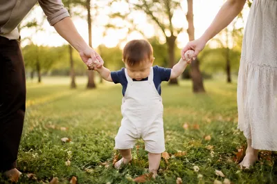 Toddler First Steps with Parents in Park
