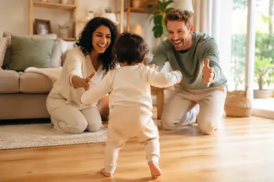 Toddler Taking First Steps Toward Parents