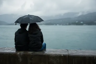 Kindness Shared Under Umbrella in Rain