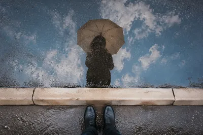 Umbrella Reflection in Rain Puddle Street
