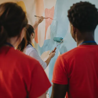 Volunteers Painting Community Mural Together