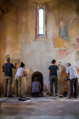 Volunteers Restoring a Rustic Community Hall Wall
