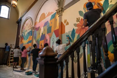 Volunteers Painting Colorful Community Hall Mural
