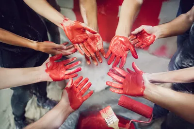 Volunteer Hands Painted Red in Community Teamwork