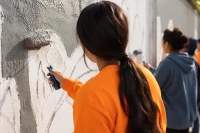 Volunteers Painting a Neighborhood Wall Together