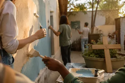 Volunteers Painting Community Wall in Warm Sunlight