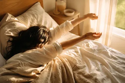 Peaceful Morning Stretch in Sunlit Bed