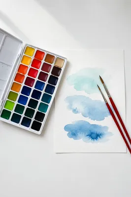 Watercolor Palette and Brushes on White Desk