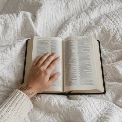 Open Bible on Cozy White Blanket