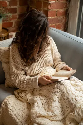 Cozy Woman Reading Bible on Blue Sofa