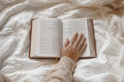 Open Bible on Cozy White Blanket